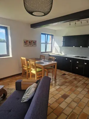 a kitchen and dining room with a table and chairs at Appartement à la campagne in Juprelle