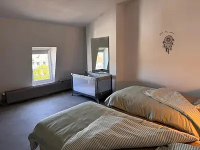 a bedroom with two beds and a dresser and a mirror at Charming Apartment in Liège City Centre with Parking Included in Liège