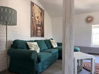 a living room with a green couch and a table at Charming Apartment in Liège City Centre with Parking Included in Liège