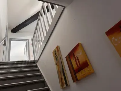 a staircase with two paintings on the wall and two pictures at Charming Apartment in Liège City Centre with Parking Included in Liège