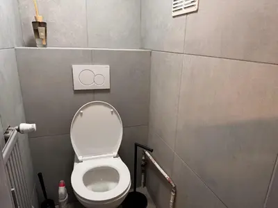 a small bathroom with a toilet with the lid up at Charming Apartment in Liège City Centre with Parking Included in Liège