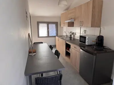 a small kitchen with a table and a microwave at Charming Apartment in Liège City Centre with Parking Included in Liège