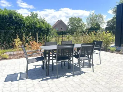a black table and chairs on a patio at Hestia in Oudsbergen