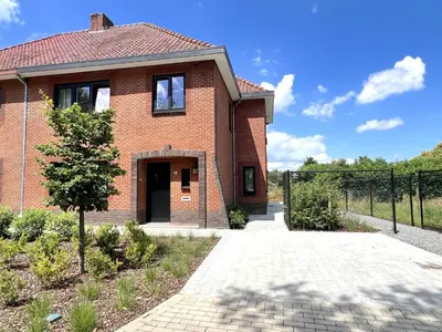 a brick house with a gate and a driveway at Hestia in Oudsbergen