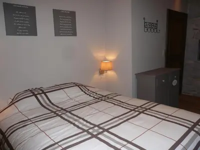 a bedroom with a bed and a table and a sign on the wall at Gite des Comagnes in Limbourg