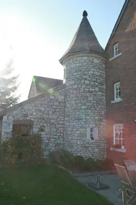 a large brick building with a tower on the side of it at Gite des Comagnes in Limbourg
