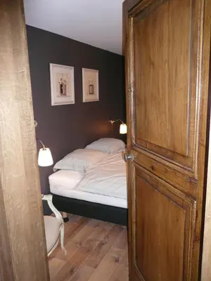 a bedroom with a bed and two pictures on the wall at Gite des Comagnes in Limbourg