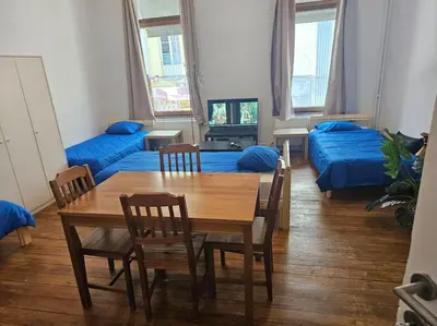 a living room with a table and chairs and a couch at Logements Liège un in Liège