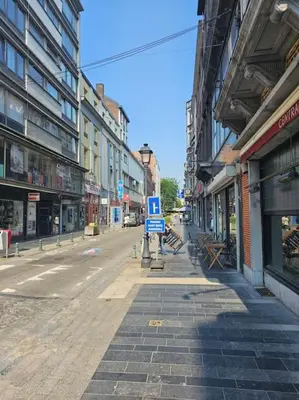 an empty street in a city with buildings at Logements Liège un in Liège