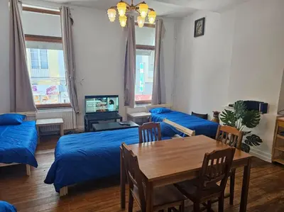 a living room with a bed and a table and a couch at Logements Liège un in Liège