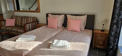 a bedroom with a large bed with pink pillows at Vakantiehuis Pippa in Peer