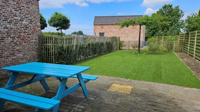 a blue picnic table in a backyard with a small yard at Vakantiehuis Pippa in Peer