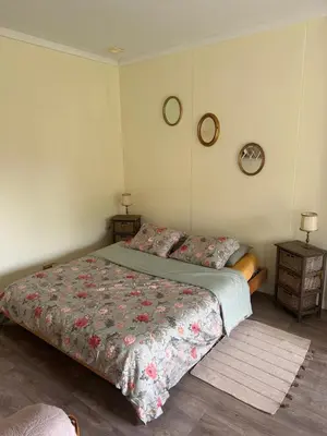 a bedroom with a bed with a floral bedspread at B&B Bombon in Herk-de-Stad