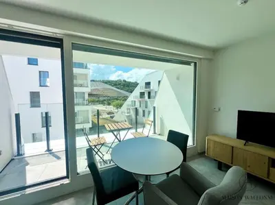 a living room with a table and a large window at Le studio des Guillemins - Boverie, Gare in Liège