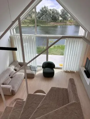 a living room with a large window and a couch at Chalet Eau Vive Mase in Maaseik