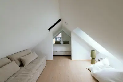 a white living room with a couch and a bed at Chalet Eau Vive Mase in Maaseik