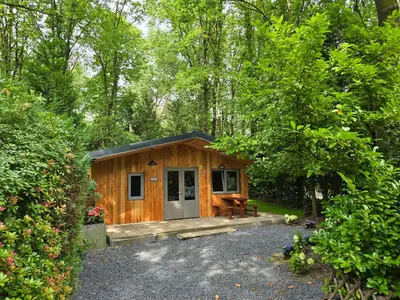 a small cabin in the middle of a forest at Tiny Lodge met prive Jacuzzi in Lanaken