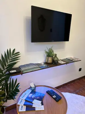 a living room with a table and a flat screen tv at La Nano Maison de Liège in Liège
