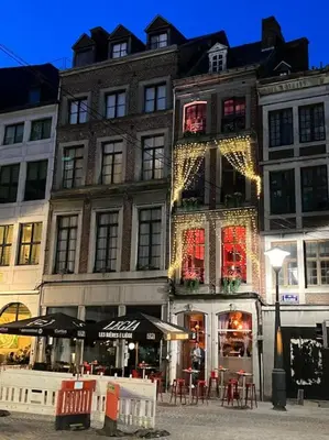 a building with christmas lights on the side of it at La Nano Maison de Liège in Liège