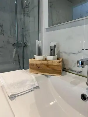 a bathroom with a white sink with a shower at Comme chez vous in Soumagne