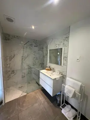 a bathroom with a marble shower and a sink at Comme chez vous in Soumagne