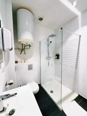a white bathroom with a shower and a toilet at Urbanchic Adalbert 1A in Liège