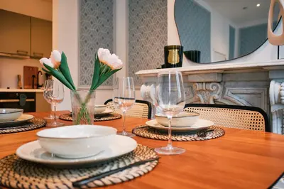 a table with plates and glasses and flowers on it at Urbanchic Adalbert 1A in Liège