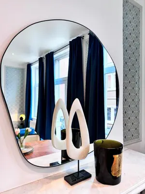 a round mirror on a table in a living room at Urbanchic Adalbert 1A in Liège
