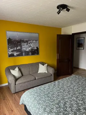 a bedroom with a bed and a couch and a painting at Casa Fratello Bolderberg in Heusden - Zolder