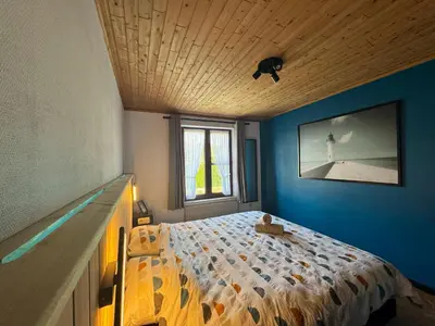 a bedroom with a bed with a blue wall at Casa Fratello Bolderberg in Heusden - Zolder