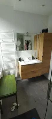 a bathroom with a sink and a mirror and a chair at Au petit 31 in Pepinster