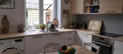a kitchen with white cabinets and a sink and a bowl of fruit at Au petit 31 in Pepinster