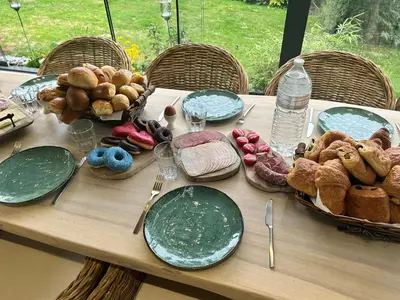 a wooden table with plates and food on it at La Maison de Rose in Riemst