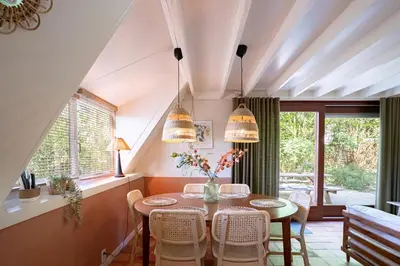 a dining room with a table and chairs at Boshuisje Rekem - Olive in Lanaken