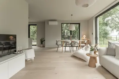 a living room with a couch and a table at Vakantie aan de Maas - Vakantiewoning Neerhof in Kinrooi