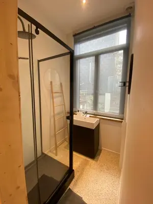 a bathroom with a glass shower and a sink at En NEUVICE 27 in Liège