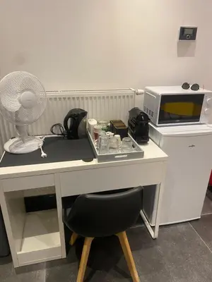 a desk with a fan and a microwave at En NEUVICE 27 in Liège