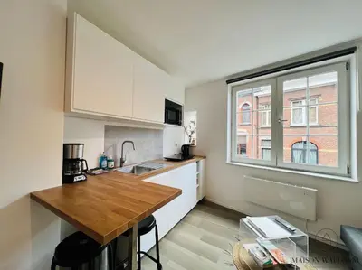a kitchen with a wooden counter top and a window at Le Wallon - Cointe Guillemins Botanique in Liège