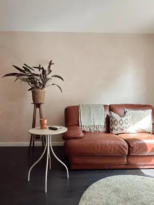 a brown leather couch in a living room with a table at Residentie Papillon in Hasselt