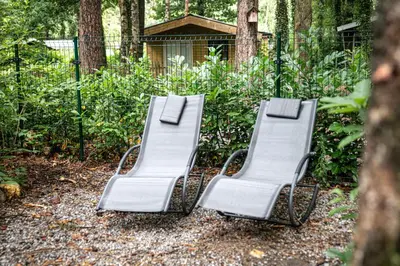 a group of three chairs sitting in a yard at Corgi-Flowerhuisje in Lanaken