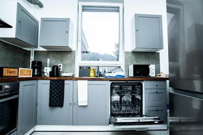 a kitchen with white cabinets and a dishwasher at Chambre R2 avec salle de bain partagée près de l'hôpital de la Citadelle à Liège in Liège