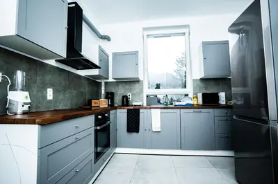 a kitchen with blue and white cabinets and a window at Chambre R2 avec salle de bain partagée près de l'hôpital de la Citadelle à Liège in Liège