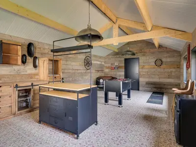 a kitchen with wooden walls and a table in a room at Vakantiehuis Bonne Home in Bree
