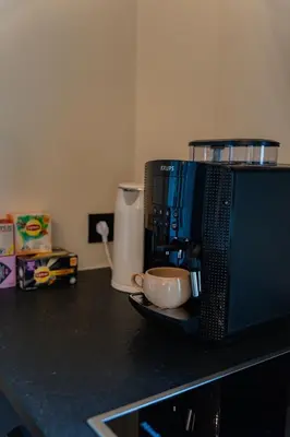 a coffee maker and a cup on a counter at Manoir du Moulin in Berloz