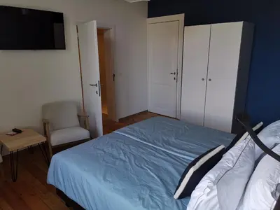 a bedroom with a bed and a chair and a television at Manoir du Moulin in Berloz