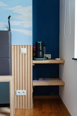 a kitchen with a blue wall and a table with a refrigerator at Manoir du Moulin in Berloz