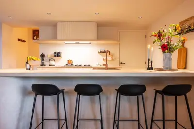 a kitchen with black stools at a counter at Stee10 in Lanaken