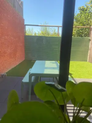 a picnic table in a courtyard with a brick wall at Chill Hill in Hasselt