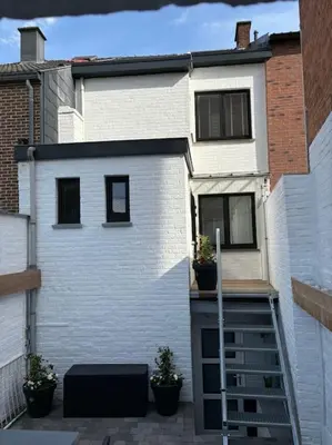 a white house with two windows and a ladder at Romagna in Tongeren