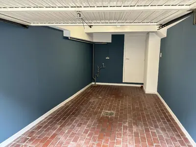 a room with a blue wall and a brick floor at Romagna in Tongeren